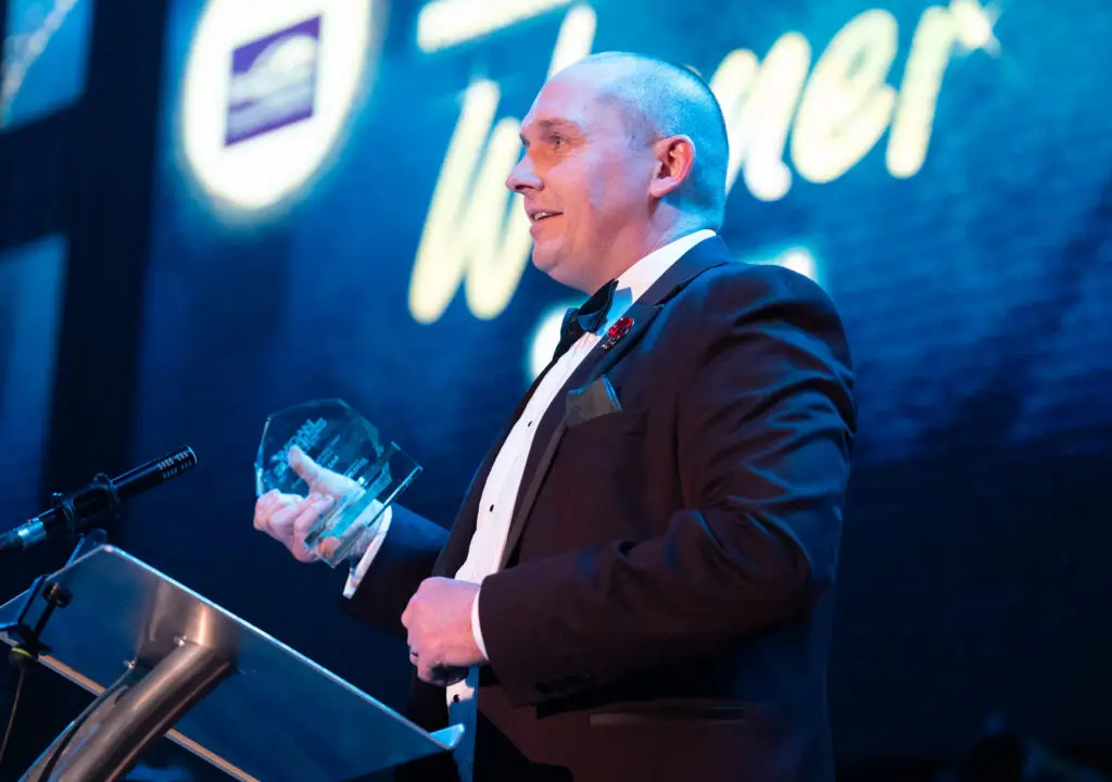 A person on stage at the Wigan Business Awards accepting an award