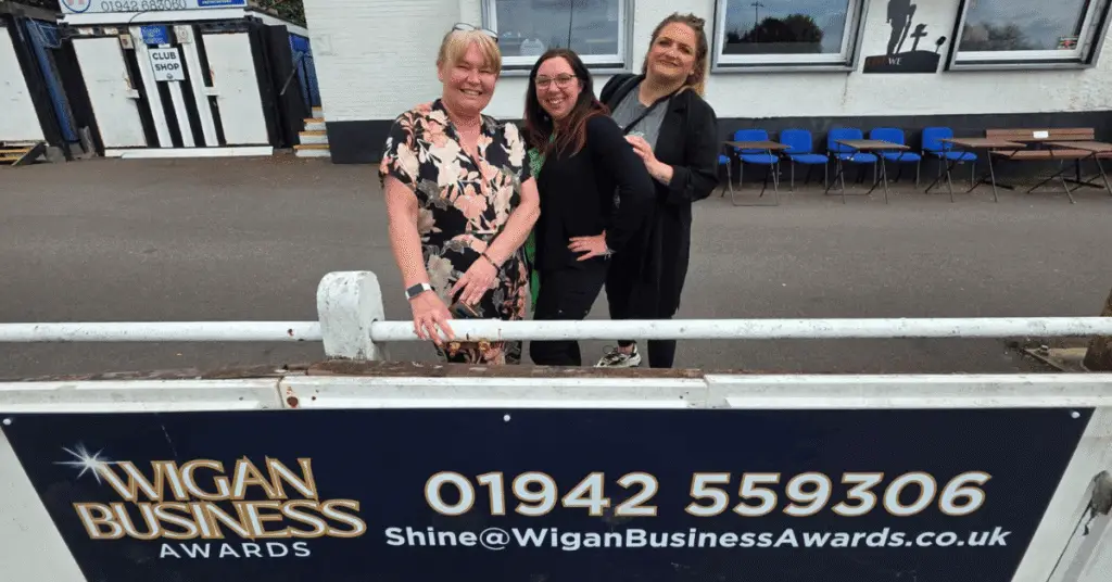Wigan Business Awards Sponsors Aspire Accounts with Organiser Nichola Howard stood behind the Awards Banner at Atherton Collieries Football Club