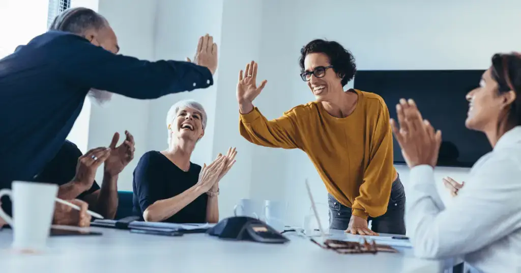 a group of people celebrating in a meeting room