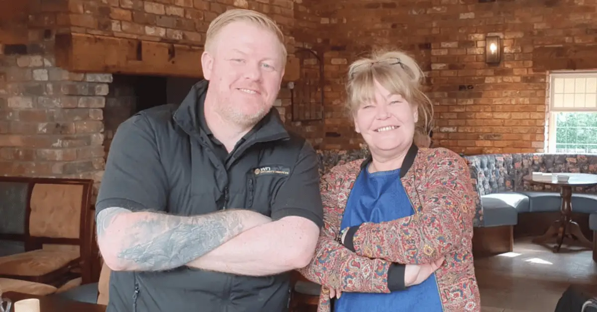 Image shows Mike Lawrenson company director at WN Security Services with Wigan Business Awards Organiser Nichola Howard from Launch North West smiling with their arms folded