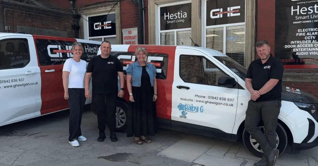 GHE fire and electrical company directors Graham Hurst and Stuart Howard with Wigan Business Awards Organisers Jo Leigh and Nichola Howard stood in front of GHE branded van and offices