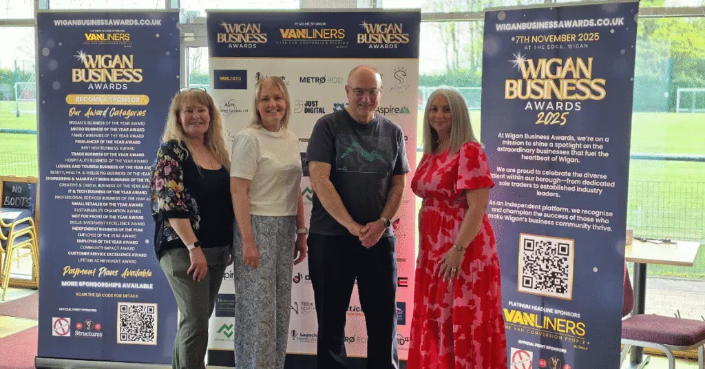 Image shows Wigan Business Awards Organisers from Right to Left Nichola Howard, Jo Leigh, Phil Paramore and Jayne Shufflebotham stood in front of branded banners