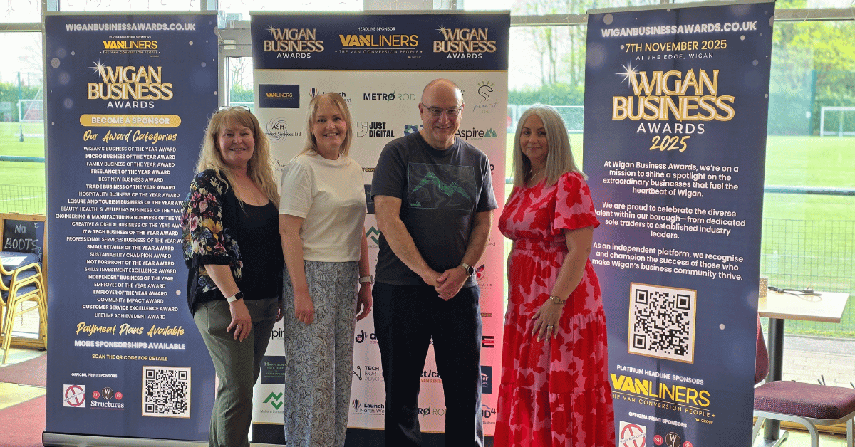 Image shows Wigan Business Awards Organisers from Right to Left Nichola Howard, Jo Leigh, Phil Paramore and Jayne Shufflebotham stood in front of branded banners