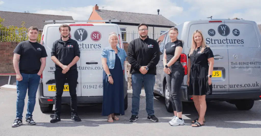 Wigan Business Awards Print Sponsors WJ Structures stood in front of their vans with Wigan Business Awards Organiser Nichola Howard
