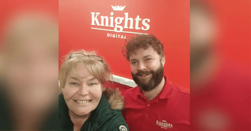 Nichola Howard from Launch NW and Dan Ackers from Knights Digital smiling in front of a red background with the Knights Digital Logo on