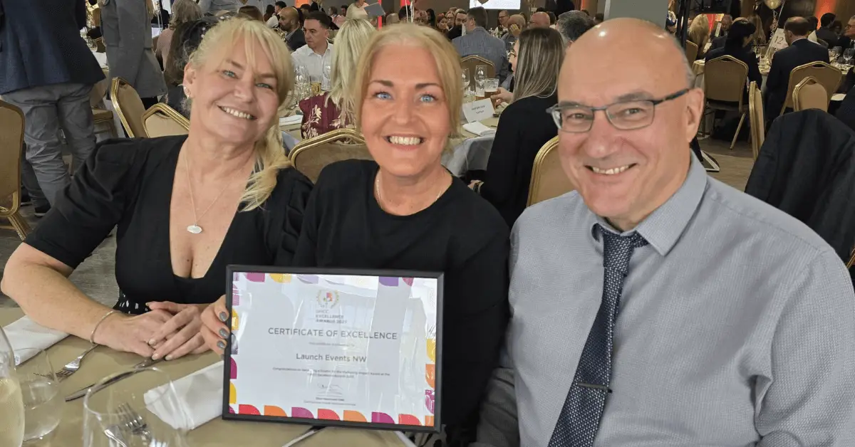 Nichola Howard, Jo Leigh and Phil Parramore from the Wigan Business Awards team smiling with their Greater Manchester Chamber Excellence Award for Marketing Impact