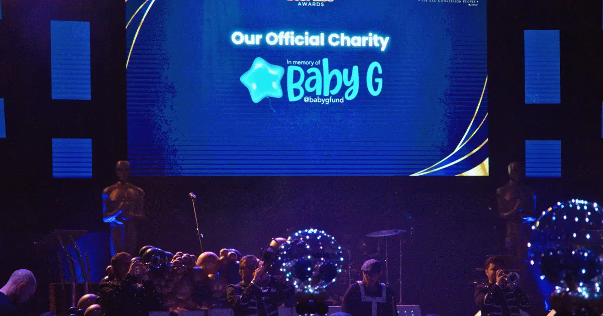a large crowd of people in front of a large screen with the words baby g on it