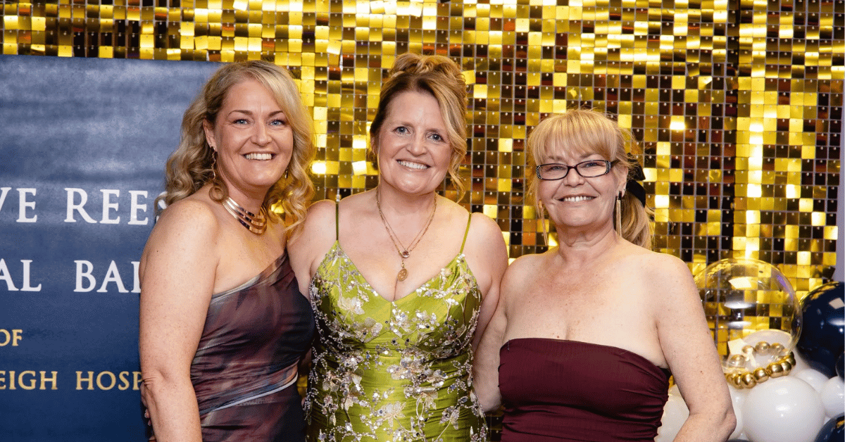 3 woman is evening dress in front of a gold sequined background
